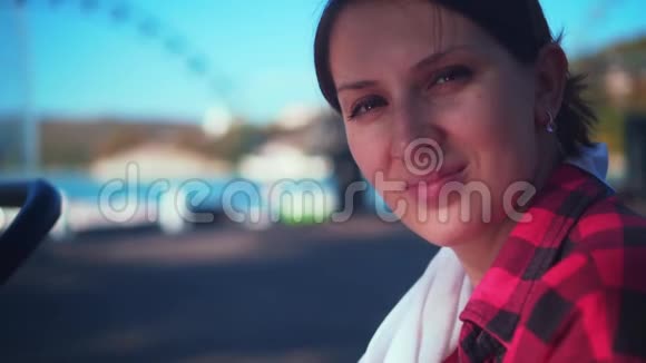 一个迷人的黑发女孩看着相机微笑一个穿着红色和黑色格子衬衫的女孩视频的预览图