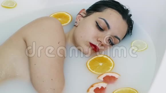 性感的女人沐浴在充满水果的牛奶浴中放松水疗和护肤理念视频的预览图