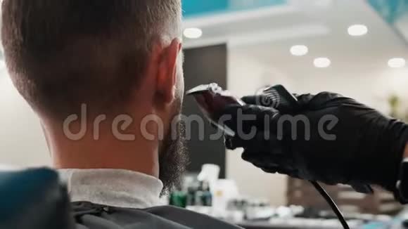 在理发店用电动剪子把剃须刀合上理发师用电动剃须刀修剪胡须视频的预览图