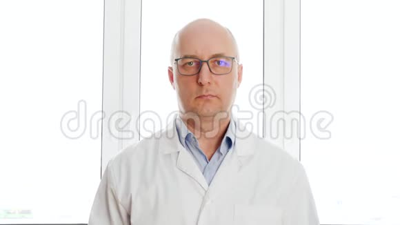 人类生物工程师穿着白色实验室外套交叉的手站在窗户背景上研究中穿白色外套的科学家视频的预览图