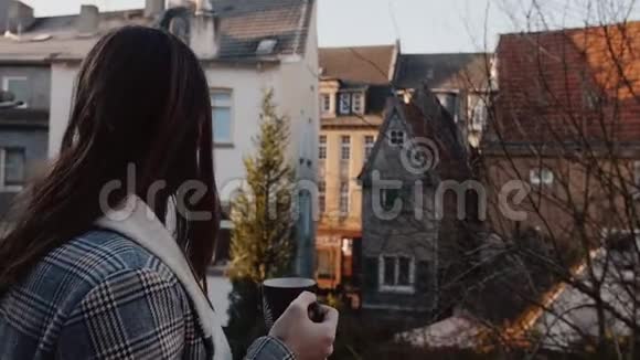 年轻快乐的白人旅游妇女在阳光明媚的老城房子阳台上喝早咖啡兴奋地微笑着慢动作视频的预览图