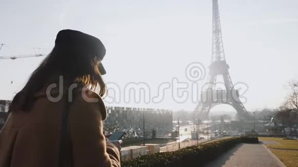 美丽的年轻优雅的女商人使用智能手机购物应用程序在阳光明媚的巴黎埃菲尔铁塔观景慢视频的预览图