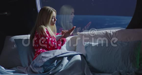 在宇宙飞船里用智能手机的女人视频的预览图