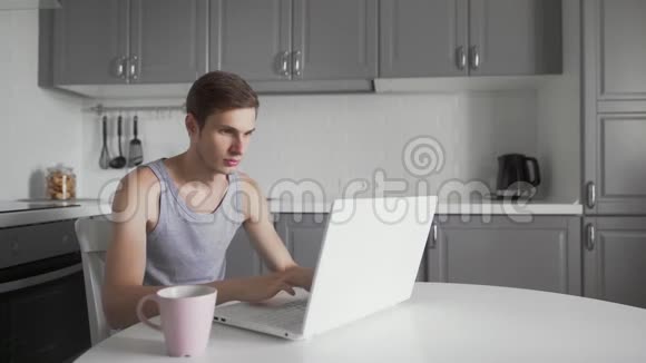 年轻人在家喝茶在笔记本电脑上工作体贴的商人视频的预览图