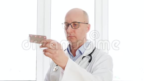 医生拿着平板水泡前摄像头关闭男药剂师在药房办公室把药丸照相机视频的预览图