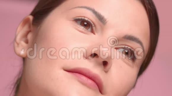 30岁的黑发女人用一个油滴管做特写在脸颊上涂点油视频的预览图