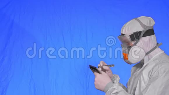 科学家病毒学家在呼吸器上用手写笔在平板电脑上写字戴防护口罩的男子视频的预览图