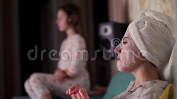肖像画女人戴着化妆面料面具头上戴着白色毛巾晚上用指甲锉把指甲锉好视频的预览图