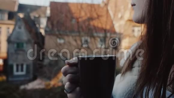 电影特写镜头年轻快乐的高加索女人在美丽的老房子喝咖啡背景慢动作视频的预览图