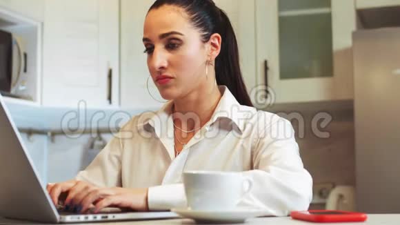 漂亮的拉丁女人在笔记本电脑上工作在工作中用电话交谈家庭工作自由职业现代技术视频的预览图