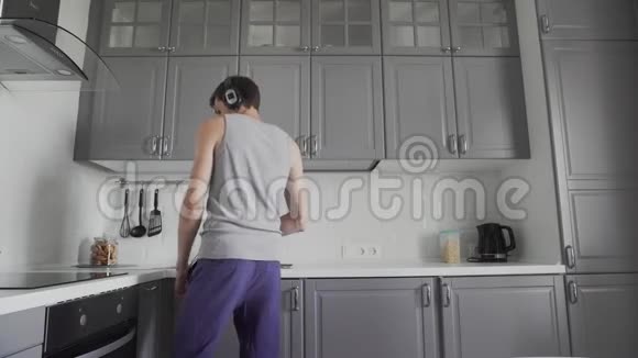 一个年轻人在厨房跳舞的肖像视频的预览图