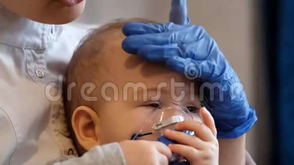 医生手中的婴儿正在进行吸入手术医生小心翼翼地抚摸着孩子头视频的预览图