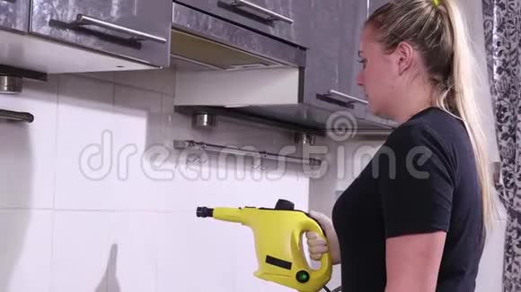 年轻女子用蒸汽清洁剂清洁厨房视频的预览图