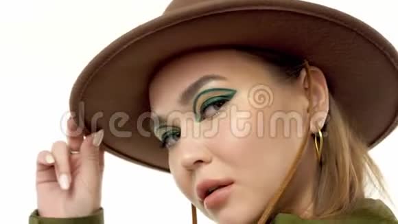 在绿皮大衣和帽子的工作室里一个秋天看的女人转身向镜头摆姿势视频的预览图
