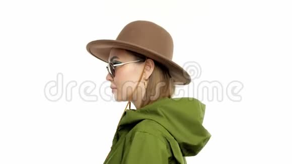 在绿皮大衣和帽子的工作室里一个秋天看的女人转身向镜头摆姿势视频的预览图