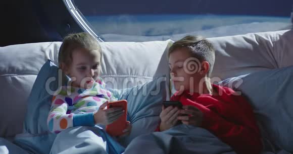 在床上使用手机的男孩和女孩视频的预览图
