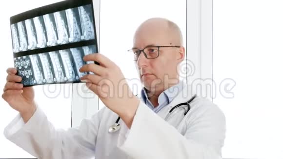 男外科医生在诊所办公室的前窗里看背骨x光男医生拿着x光脊椎骨视频的预览图