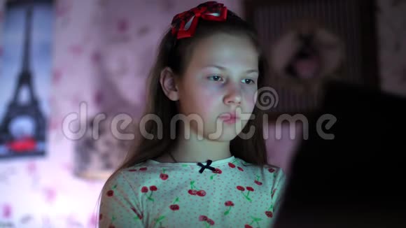 穿着睡衣的女孩晚上在卧室里用笔记本电脑看视频肖像画视频的预览图