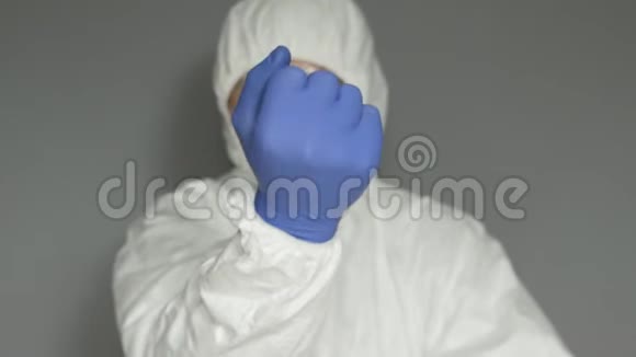 一位穿着防护服口罩和眼镜的生物学家伸出手来手里拿着两片黄色的药丸视频的预览图