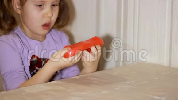 小女孩玩着做平泥孩子玩手工制作的玩具黏液放松和满足令人奇怪的是视频的预览图