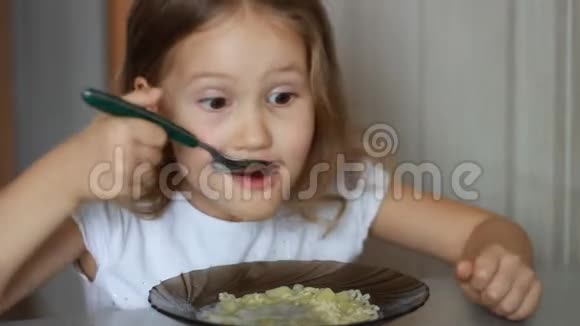 孩子用勺子吃汤特写女婴坐在餐桌前做家常菜吃美食视频的预览图