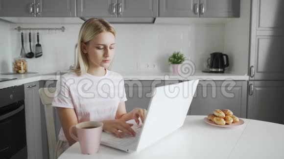 年轻女子在家里用笔记本电脑休息视频的预览图