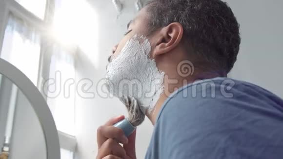在镜子后面的人在他早上的面部护理剃须常规视频的预览图