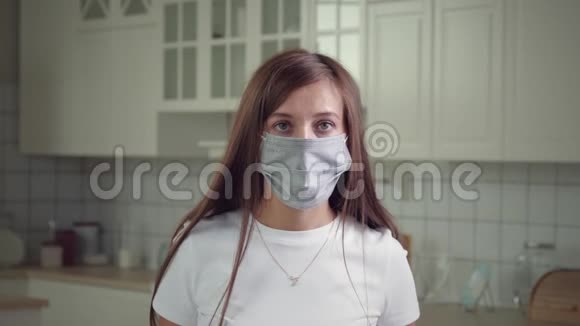 戴着医疗面具和看镜头的白人女性视频的预览图