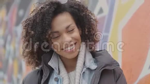 美丽微笑的年轻女子非洲发型户外涂鸦视频的预览图