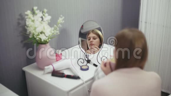 年轻可爱的女人在镜子前喝咖啡视频的预览图