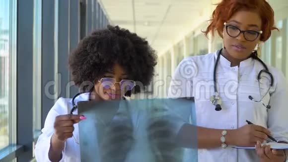 两位非裔美国女医生检查肺部x光手拿在室内两名专家视频的预览图