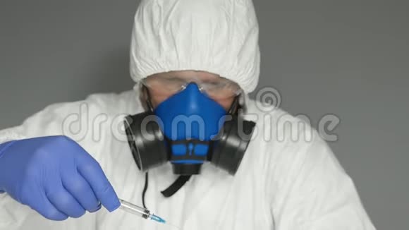 穿防护服的生物学家面具他戴着眼镜和手套把安瓿中的疫苗注射到注射器中视频的预览图