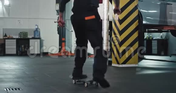 一个穿着制服的滑板技工在现代汽车服务中心的工作场所玩得开心视频的预览图