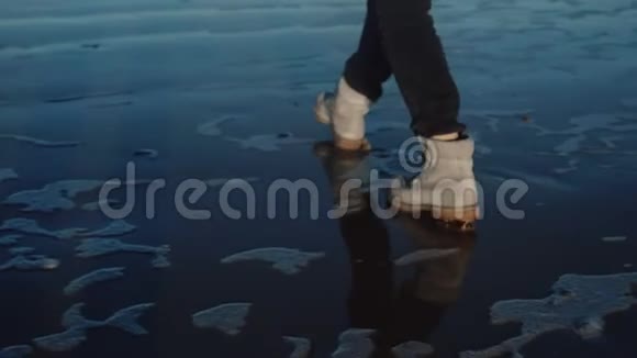 后景特写在旅游妇女的腿上沿着镜子行走像风冷的海岸相机倾斜缓慢的运动视频的预览图