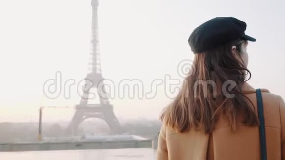 在巴黎的特罗卡德罗雾蒙蒙的埃菲尔铁塔附近快乐的黑发旅游妇女沿着慢动作的电影轨迹视频的预览图
