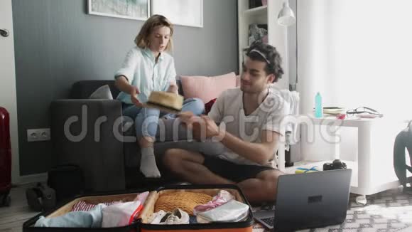 一个男人和一个女孩说话把度假的东西放在手提箱里视频的预览图