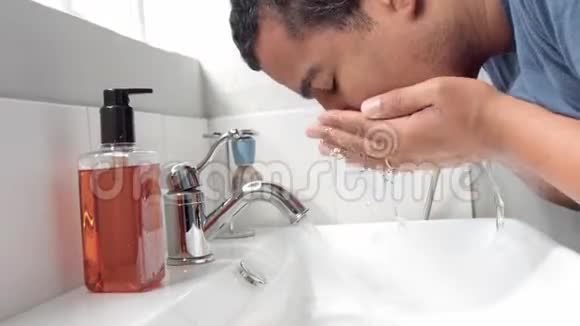 在他早晨的面部护理过程中男人洗脸视频的预览图