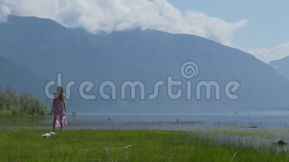 女孩走在原木上跳跃旋转抓住她裙子的下摆视频的预览图