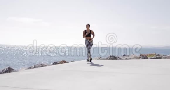 穿着运动服的女孩在海滨跑步视频的预览图