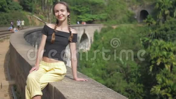 女孩在丛林中坐在广受欢迎的桥上度假视频的预览图