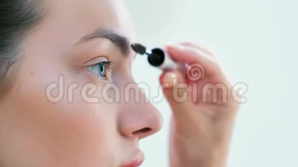 女性用刷子或睫毛膏做眉毛的年轻美女视频的预览图