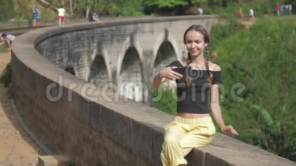 有辫子的漂亮女孩在旧桥墙上自拍视频的预览图