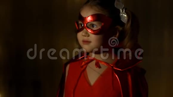 可爱的女婴微笑着扮演超级英雄搞笑宝宝穿红雨衣打权力超级英雄超级英雄和超级英雄视频的预览图