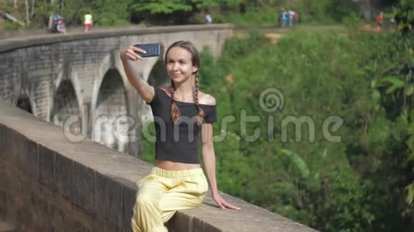 穿黑色上衣的漂亮女孩在旧桥墙上自拍视频的预览图