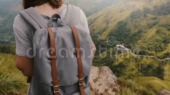 特写镜头跟随着快乐的游客她背着背包和相机欣赏着斯里兰卡令人惊叹的山景景色视频的预览图