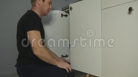 一名男水管工在厨房修理排水装置时被一股水射流击中脸部有条旧水管视频的预览图