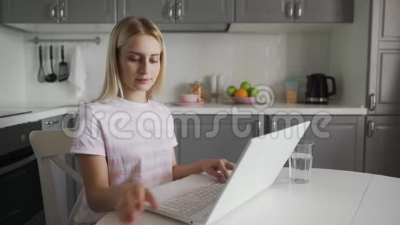 家庭厨房里的自由职业者使用手机的女性视频的预览图
