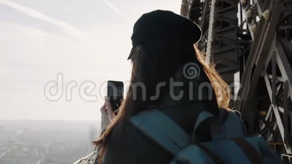 快乐微笑的旅游妇女在埃菲尔铁塔顶部拍着巴黎风景的电话照片欢快地笑着慢动作视频的预览图