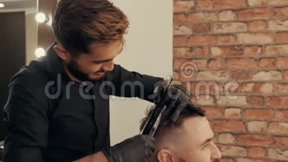 在理发店做时髦发型的年轻人理发师梳头用剪发刀剪发视频的预览图