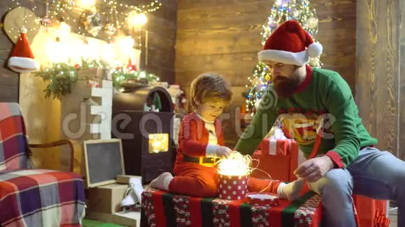 快乐的父子带圣诞礼盒圣诞礼物的情感新年概念快乐的小儿子视频的预览图